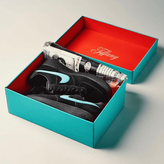 View of black Nike shoes in a teal box.